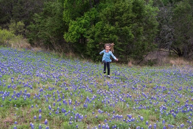 Kyndal Britt Peevey skips through a field of bluebonnets near Inks Lake, Texas