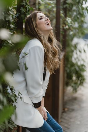 Woman sitting on planter in garden