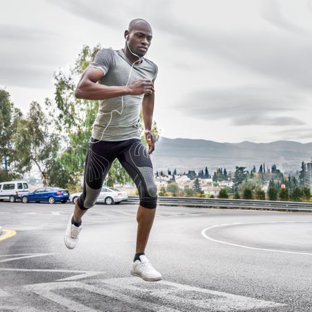 Healthy male running on city street