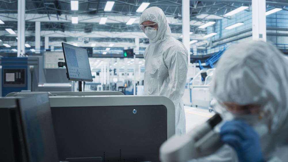 Scientists in hazmat protective suits working in lab