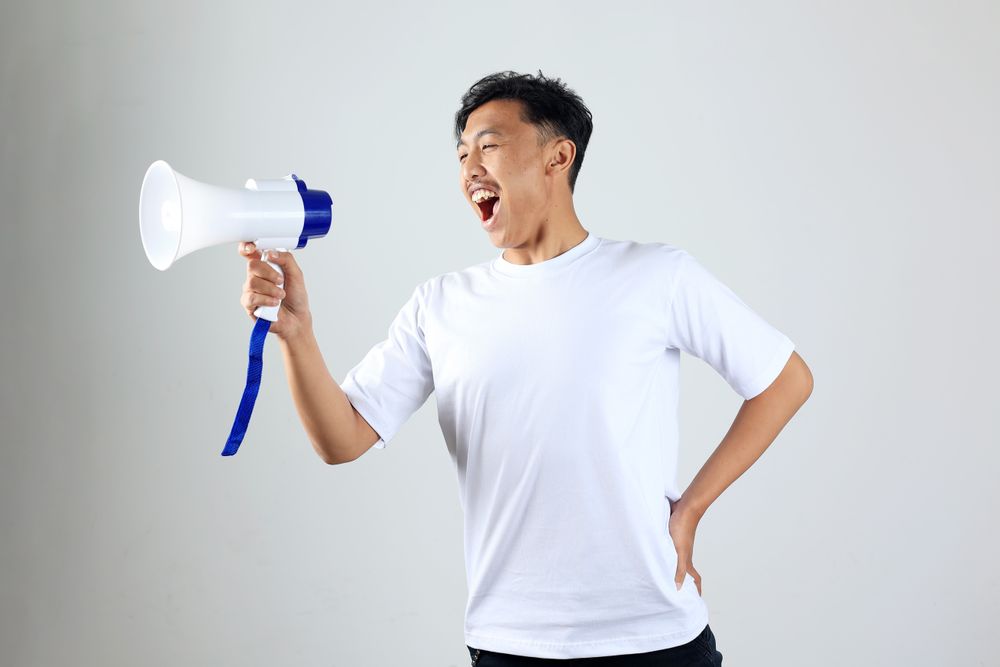Asian Young Man in T shirt Shouting Using Megaphone