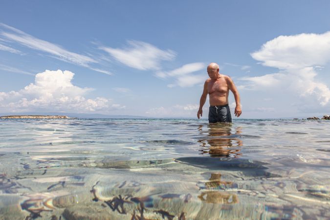 Cheerful man swimming in sea water