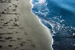 Dark volcanic beach and sea