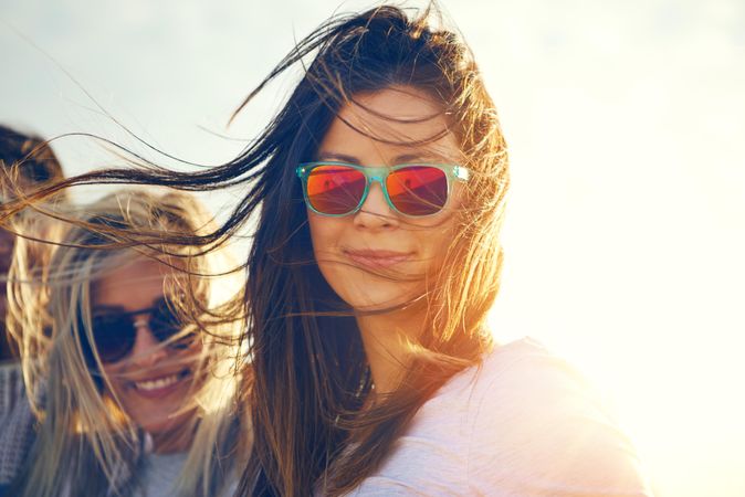 Woman in reflective sunglasses on sunny day with friends