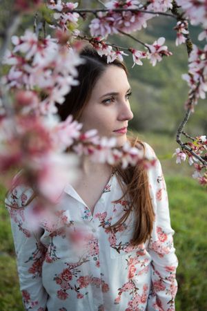 Young happy woman between trees in garden