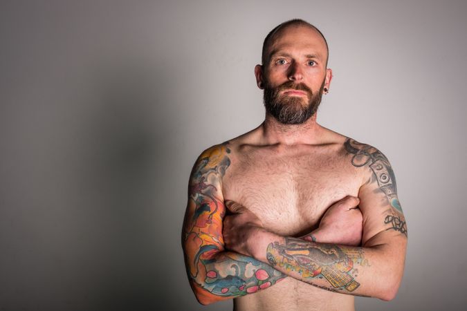 Young bearded guy with tattoos on hand