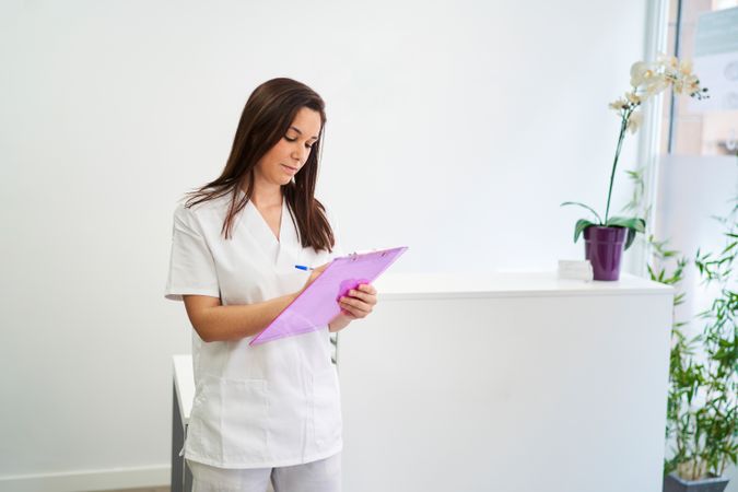 physiotherapist at the clinic reception preparing the list of pa