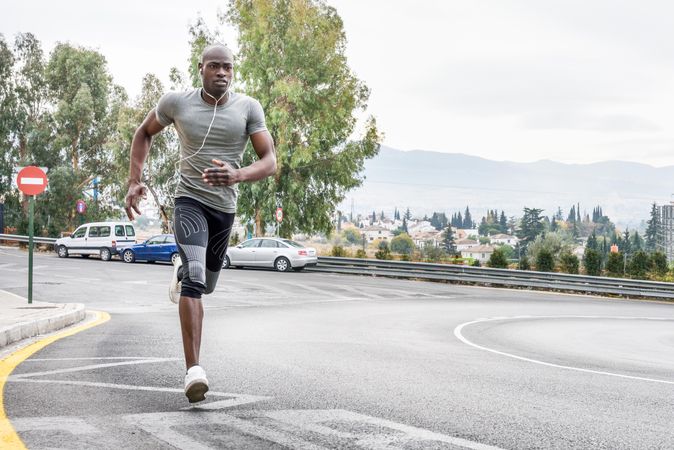 Fit male jogging on city street