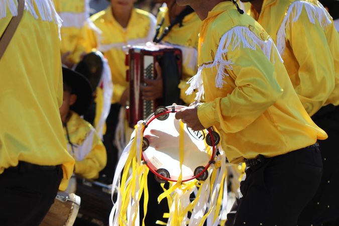 Group of men in yellow outfits playing music at religious festival in Minas Gerais, Brazil