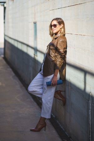 Chic woman leaning on wall with shadow