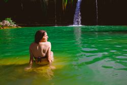 Anonymous woman looking at waterfall