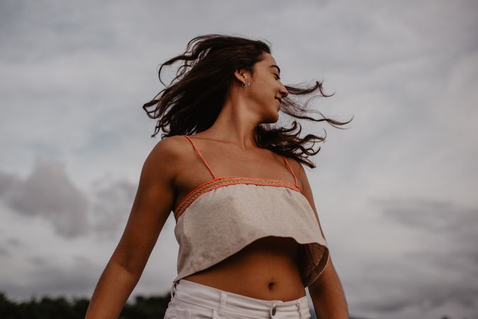 Cheerful woman dancing near lake