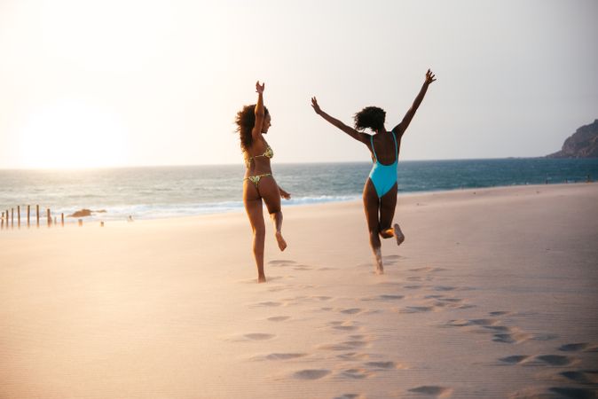 Unrecognizable women enjoying on beach in swimsuit