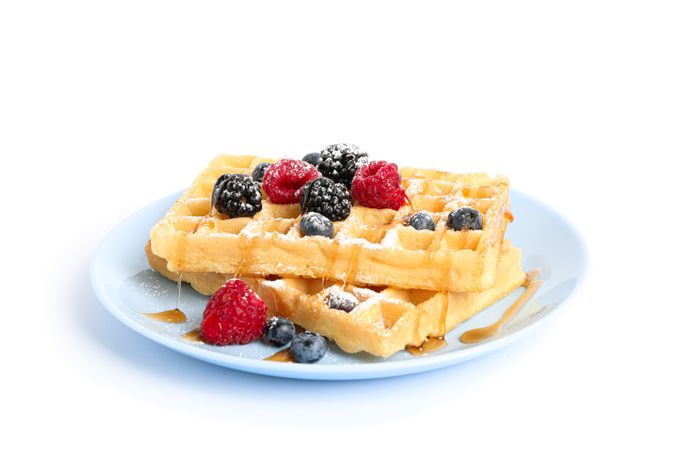 Waffles with berries on plate isolated on blank background