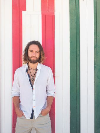 Cheerful guy standing near striped wall