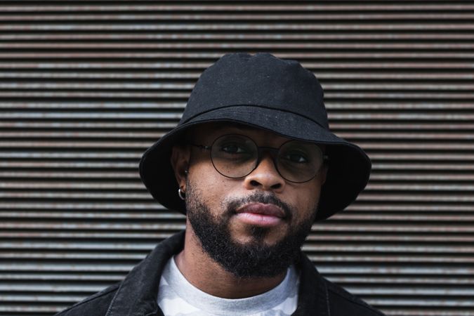 Black hipster man in hat looking at camera