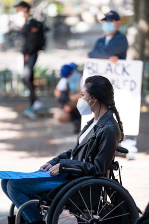 Los Angeles, CA, USA — June 16th, 2020: woman with mask on listening to speakers at protest rally