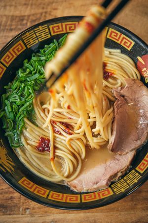 Delicious ramen with cooked noodles on chopsticks