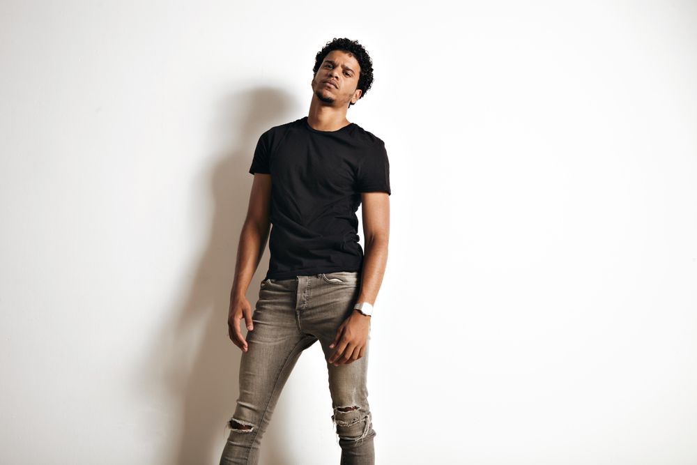 Serious male model standing in bright room