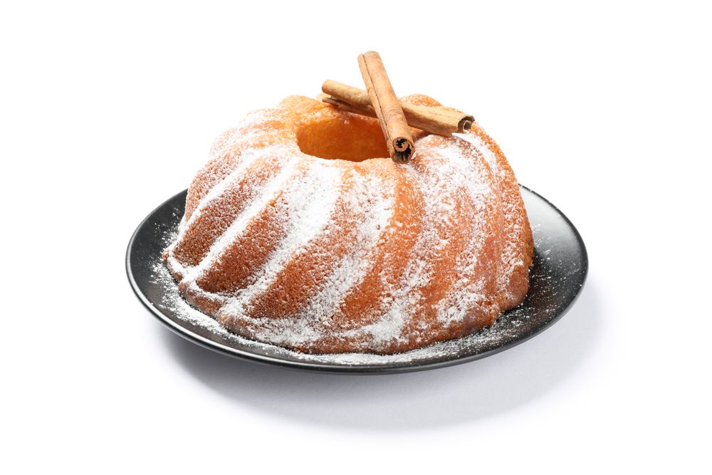 Cake with powder sugar and cinnamon isolated on blank background