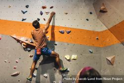 Climber practicing rock climbing at indoor climbing gym bDglQ4