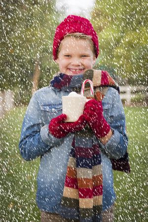 Young Boy in Warm Clothing Holding Hot Cocoa Mug Outside