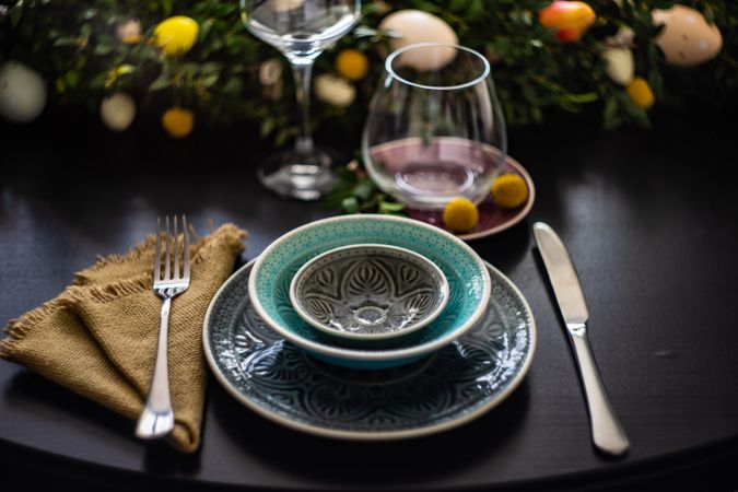 Spring table setting with patterned plates on table with floral centerpiece