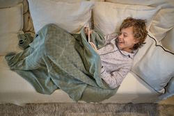 Delighted boy reading book on sofa