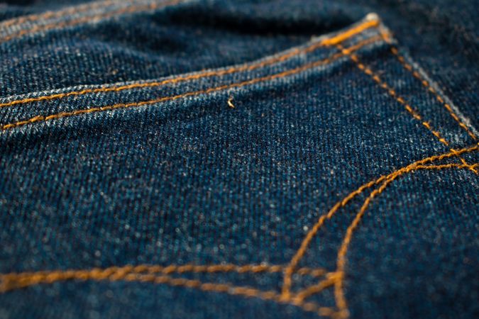 Close up Back pocket of navy blue jeans fabric texture background