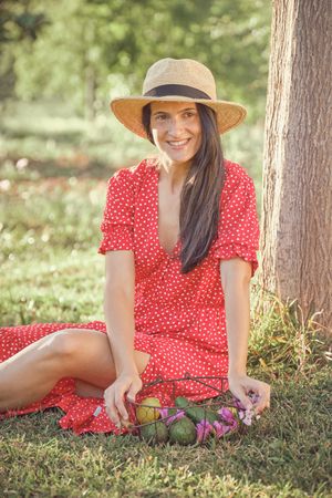Young woman in summer dress sitting on grass