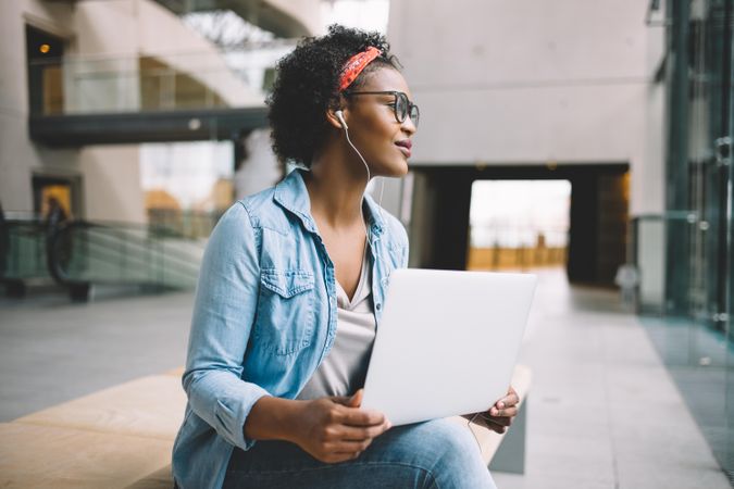 Woman thinking through problem with computer on lap