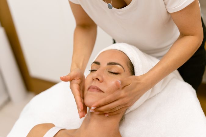 Woman relaxing having her jaw and neck massaged