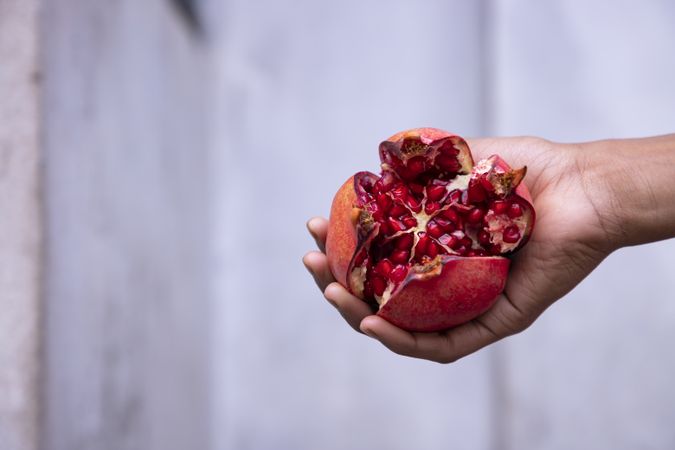 Ripe pomegranate fruit in hand