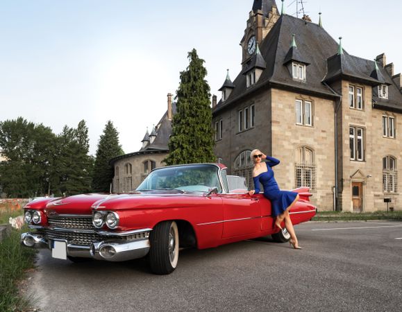 Red vintage car with a chic woman in dress
