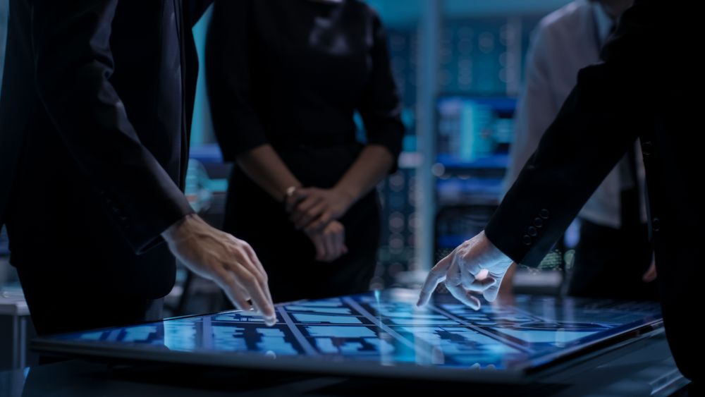 Corporate Managers Working at the Table in Monitoring Room.