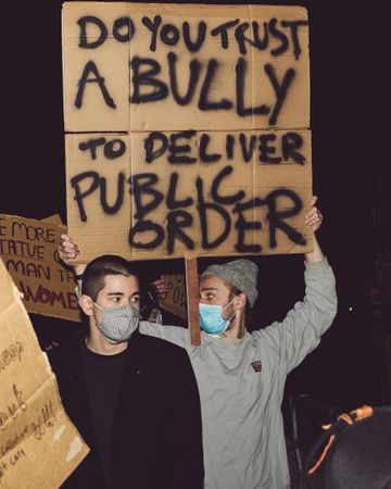 London, England, United Kingdom - March 16, 2021: Two men holding protest signs