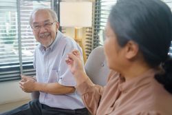 Asian couple talking together in the living room