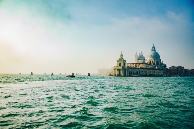 Waves on water surface and old building on shore