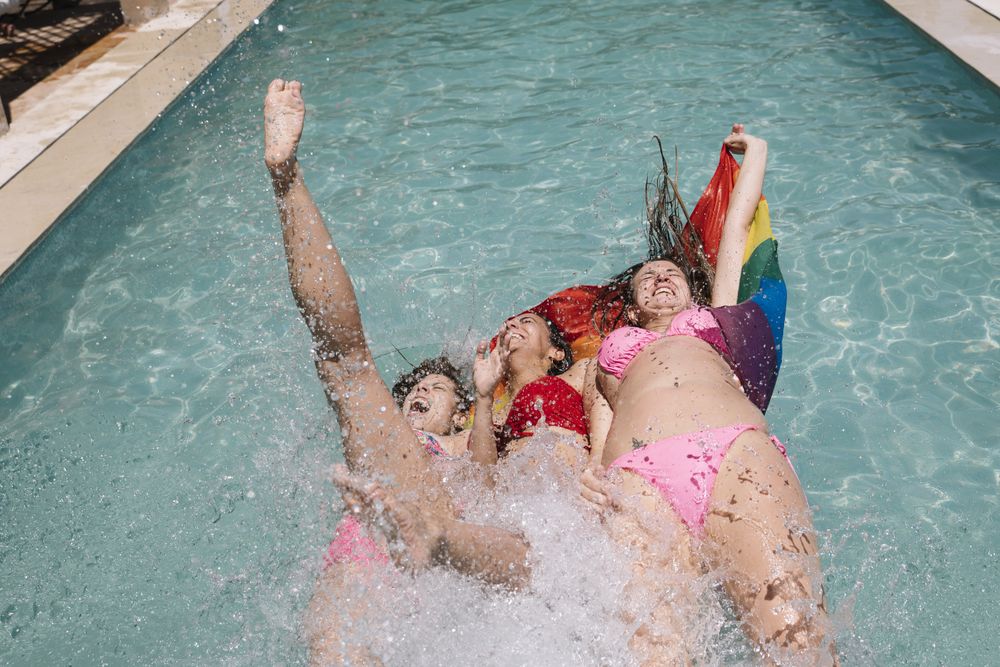 Anonymous lesbians splashing in swimming pool
