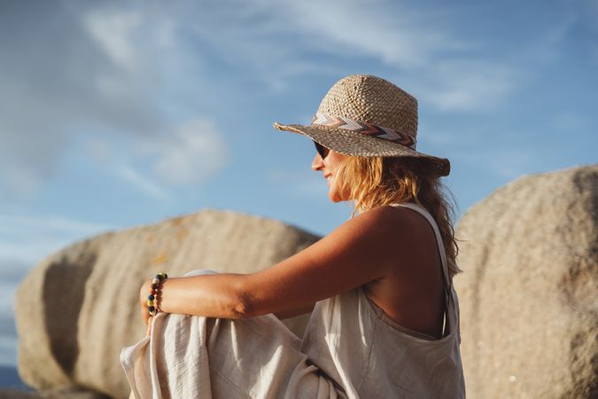 Carefree woman enjoying rest on coast near cliffs