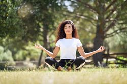 Arab woman doing meditation in field