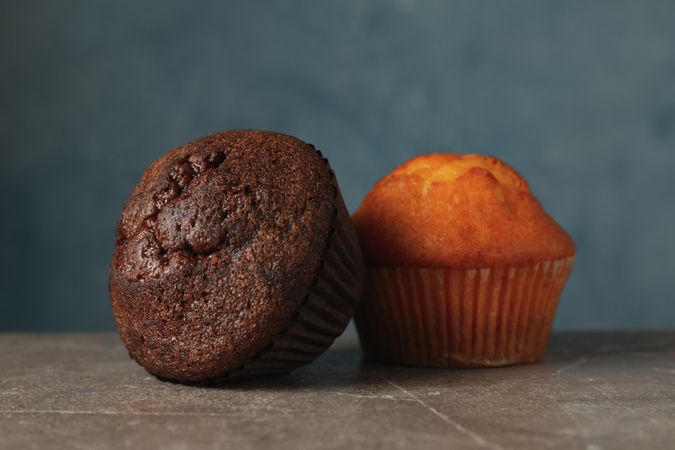 Delicious tasty muffins against blue background. Sweet food