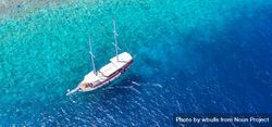 Aerial shot of boat in tropical blue waters, wide bx89db