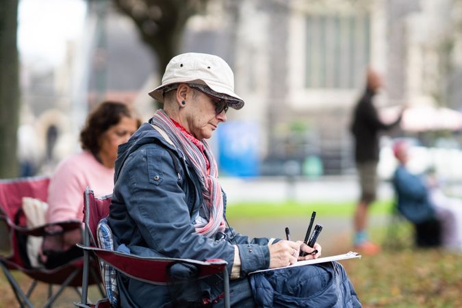 Side view of man drawing outside