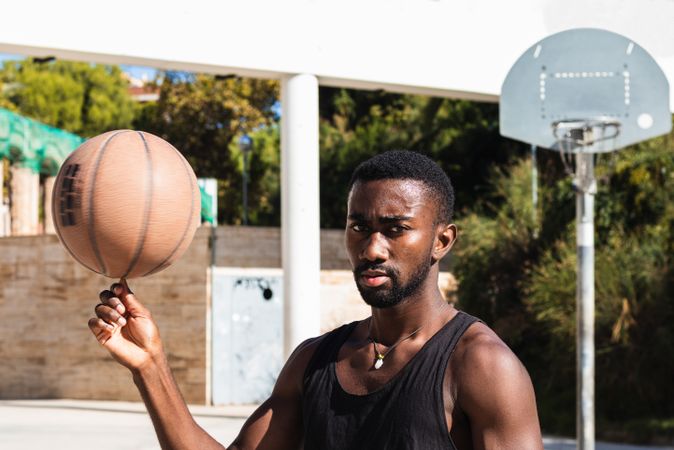 Black man spinning basketball on finger
