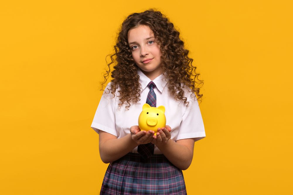 Girl holding a yellow piggy bank