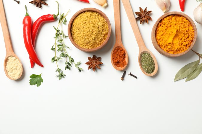 Colorful spices and wooden spoons with copy space