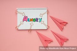 Notepad with “memory” written in colorful markers with paper planes 4ZYNx5