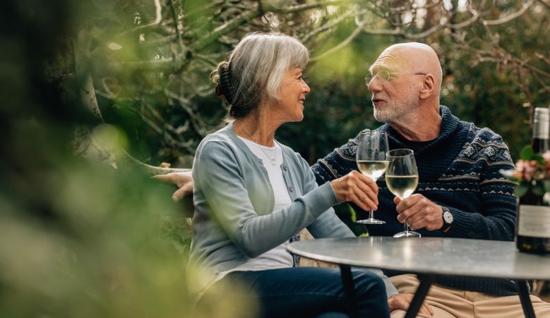 Older man and woman spending time together drinking wine