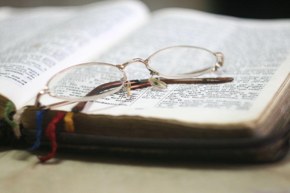 Silver framed eyeglasses on book page